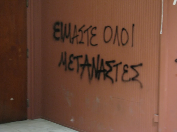 graffiti written on a wall in a public restroom
