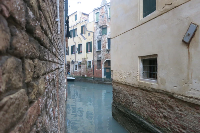 a narrow canal with water running between two buildings