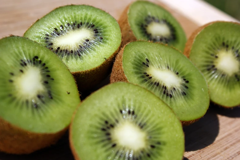 a bunch of kiwi sitting on top of a  board