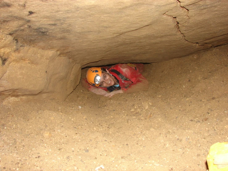 a man wearing a red and orange helmet standing in an underpass