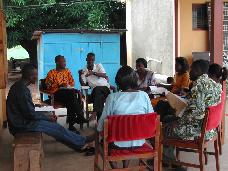 several people are sitting in a group outside