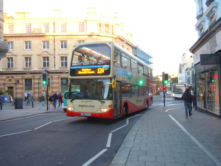 a red and grey double decker bus driving down the street