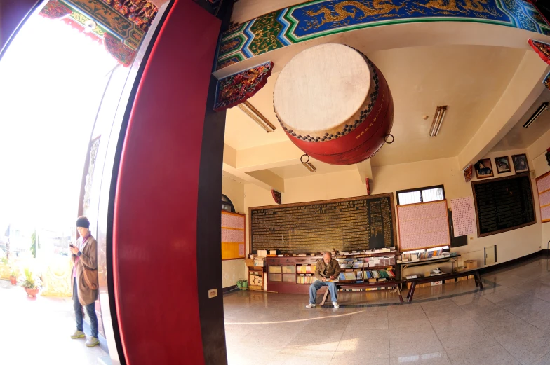 the mirror reflects people sitting at tables and colorful art