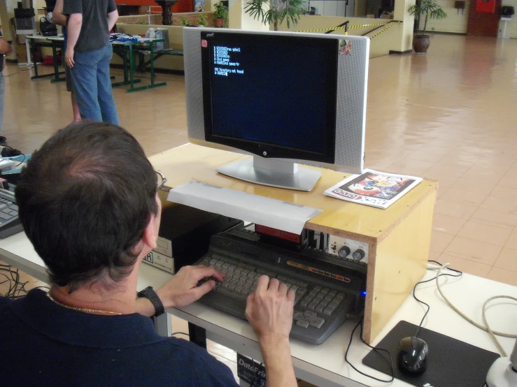 man using small computer with speaker attached to it