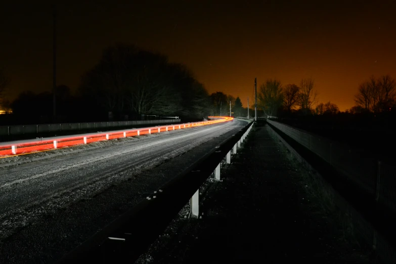 a road with a fence on each side at night