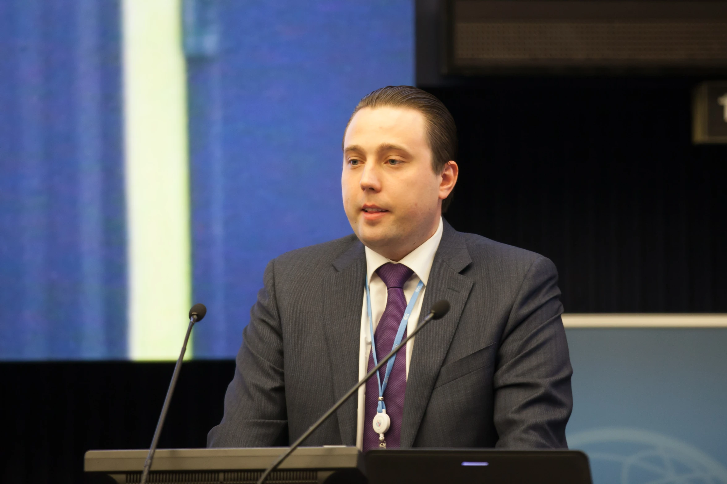 a person at a podium wearing a suit and tie