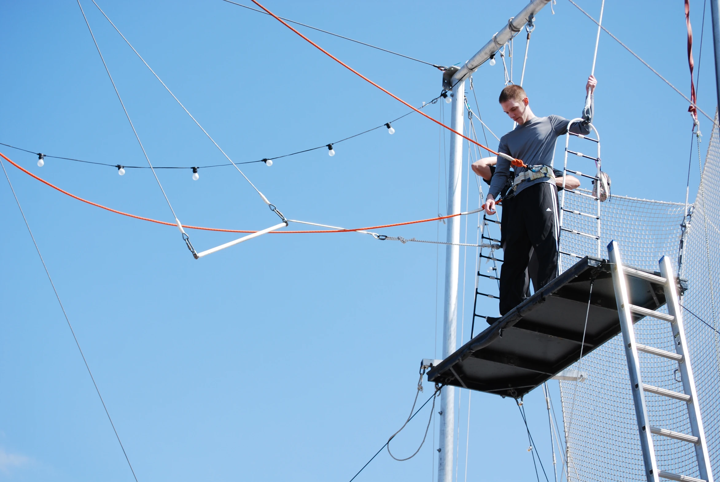 a man on a ladder climbing a tower in the sky