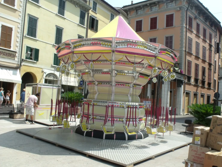 an elaborate carousel set in front of some colorful buildings