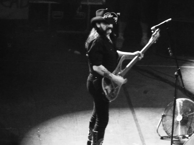 a man standing in the dark with a guitar