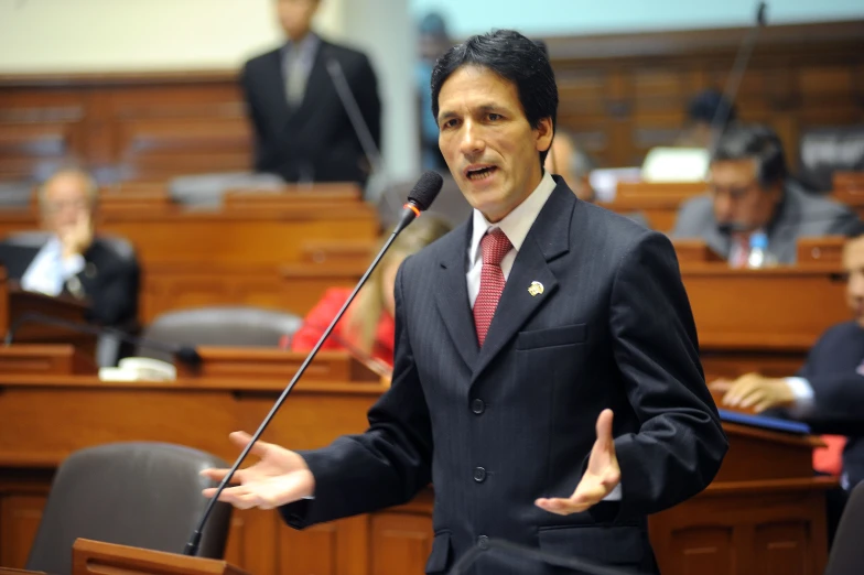 the man is giving a speech during a meeting