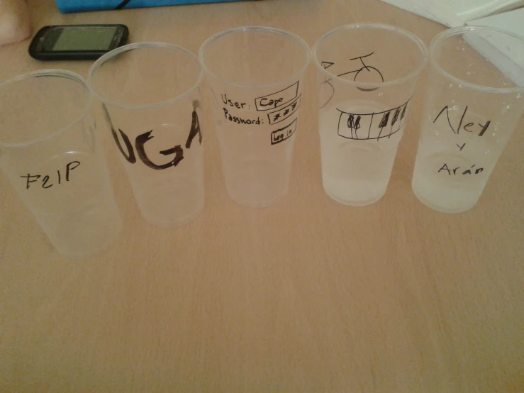 a bunch of glasses sitting on a table with writing on them