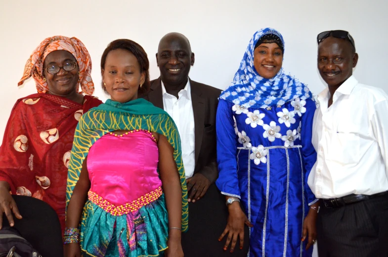 several smiling people wearing colorful dress and head coverings