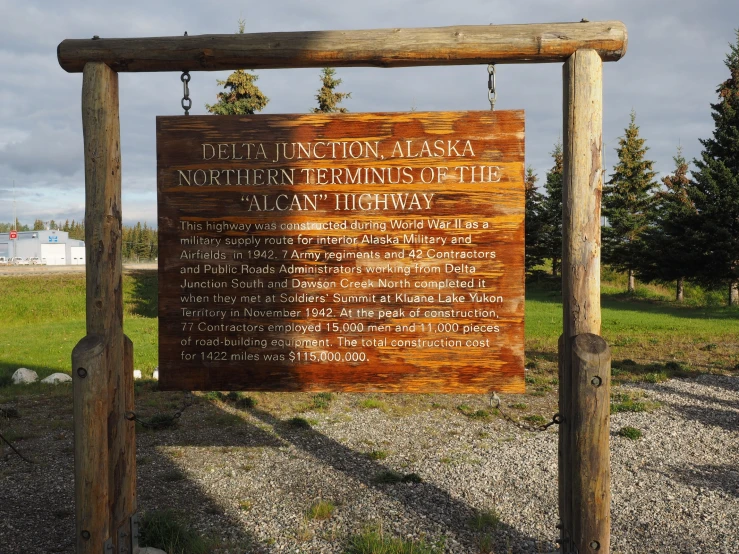 sign with hanging chain attached to wooden post