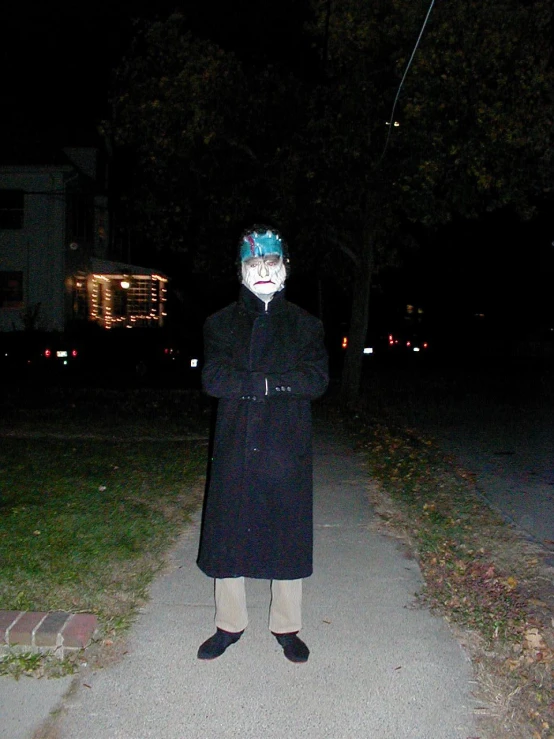 a man with blue hair and a mask stands in a road