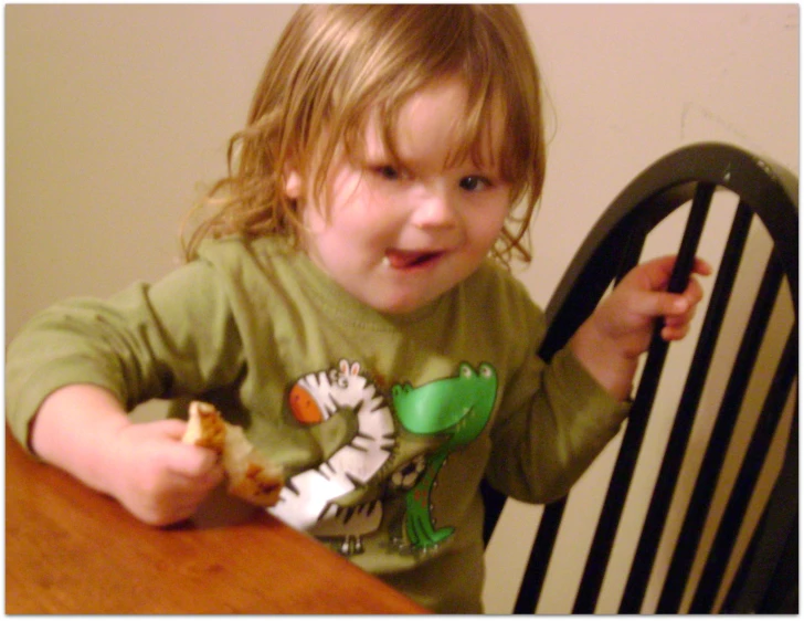 a girl wearing green holding a wooden spoon in her hand