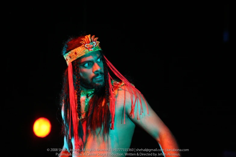 a man with long hair wearing red, pink and orange