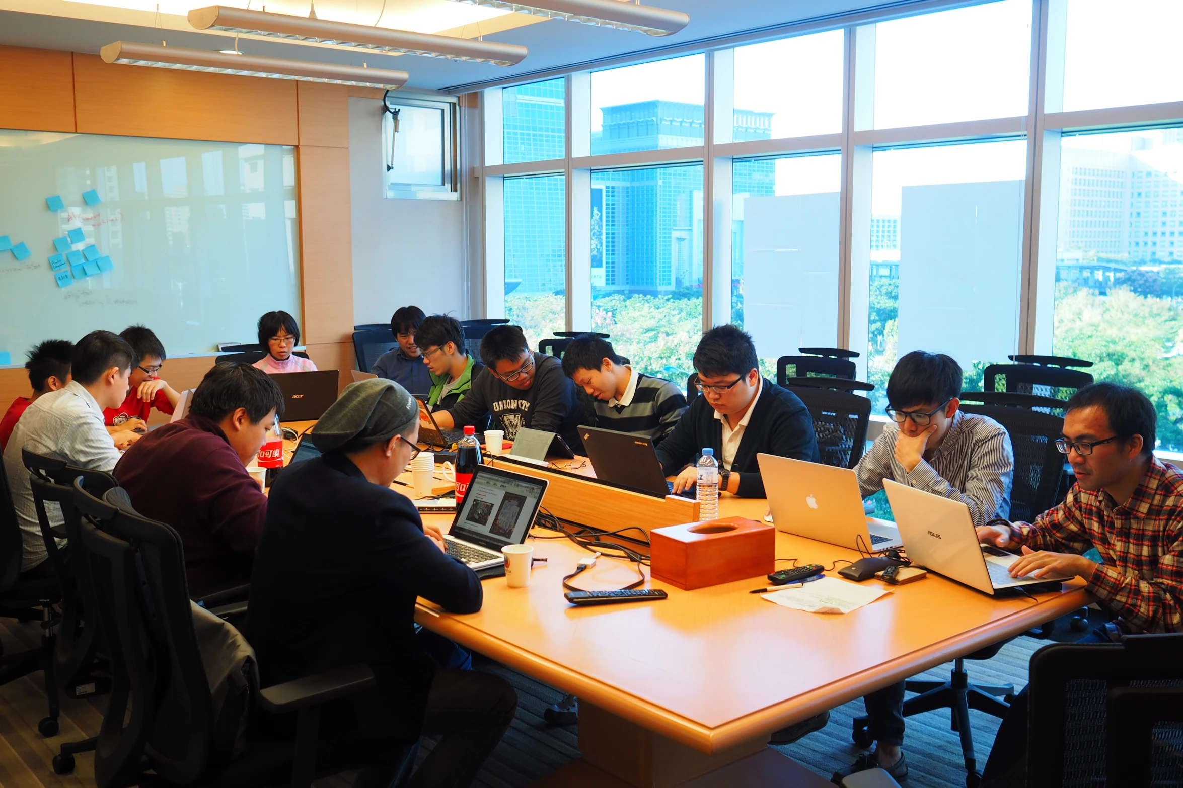 group of people at tables working on laptops