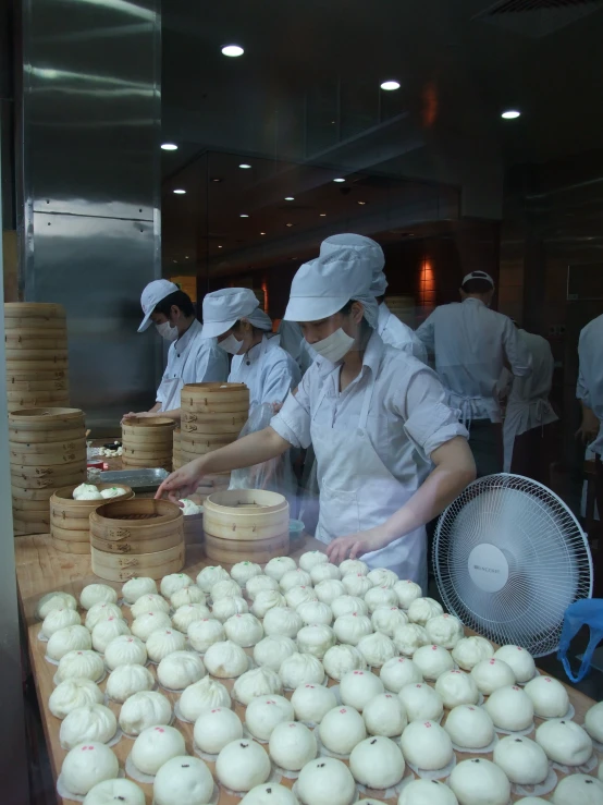 there are many cooks wearing white uniforms making food