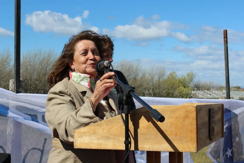 a woman is standing behind a podium and a camera