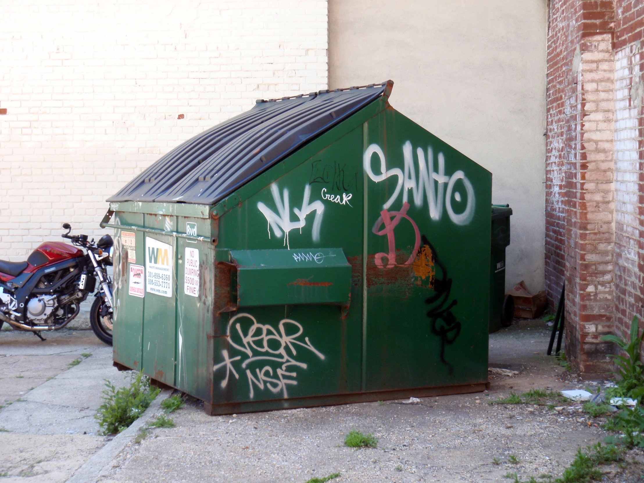 a small green storage box on side of a building