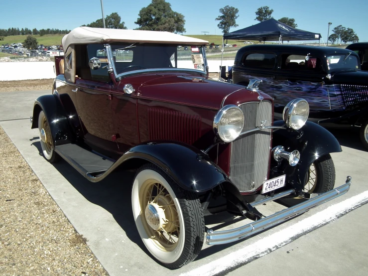 an old fashioned brown car is parked at a car show