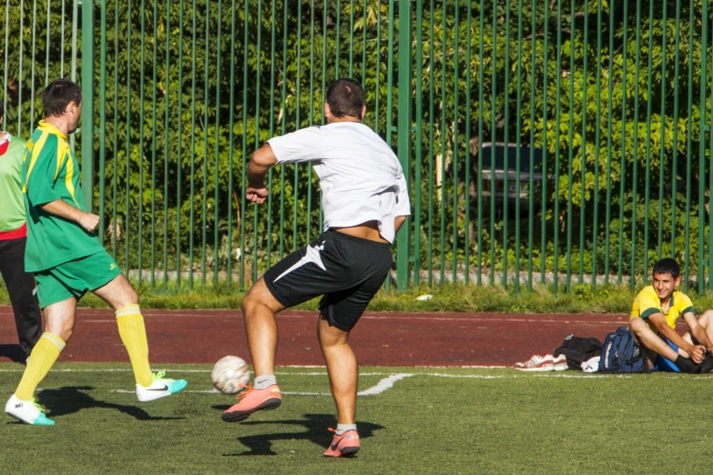 two soccer players on opposing teams trying to block the ball