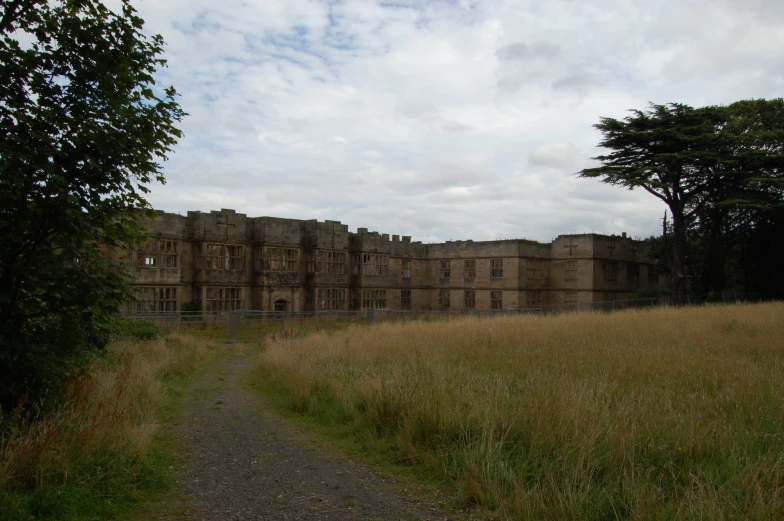 the abandoned building is in the middle of the green grass