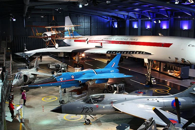 jet fighters displayed inside an airplane hanger at a museum