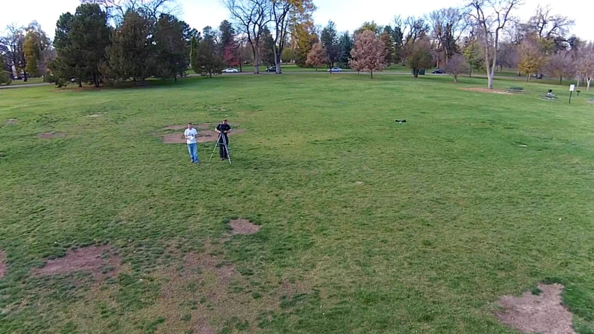 a couple of people standing in a green field