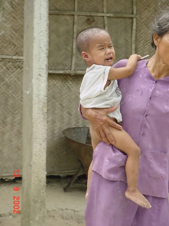 an elderly woman holding a small child in her hands