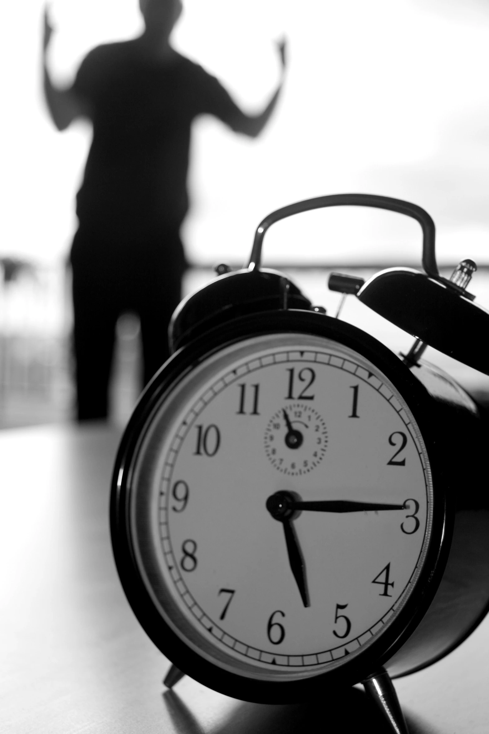 an alarm clock with a person in the background