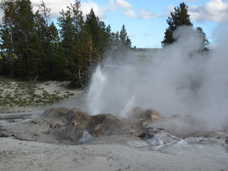 a small geyser of water emits from a rock