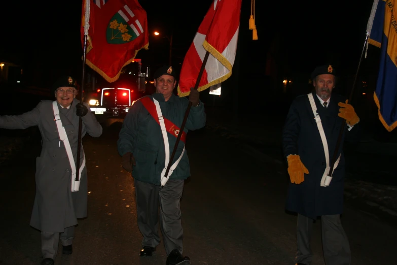 a group of people carrying flags walking on the street