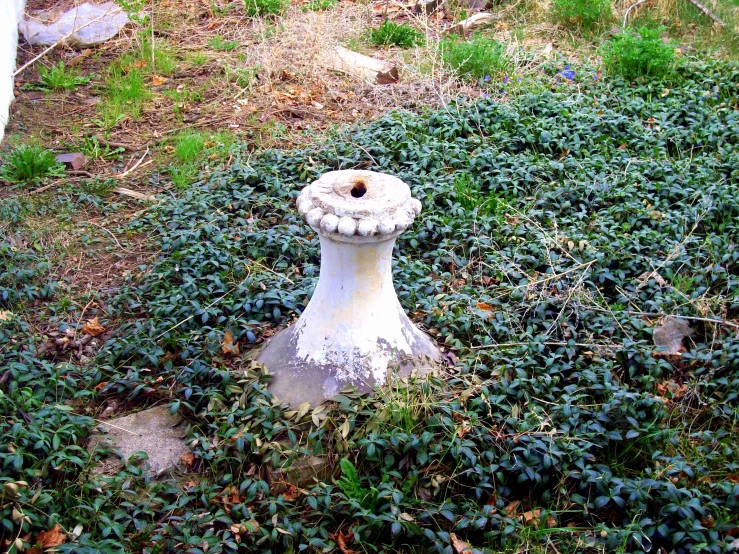 a very old concrete object sitting in the middle of a field