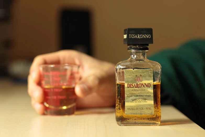 a bottle of liquor with an empty glass