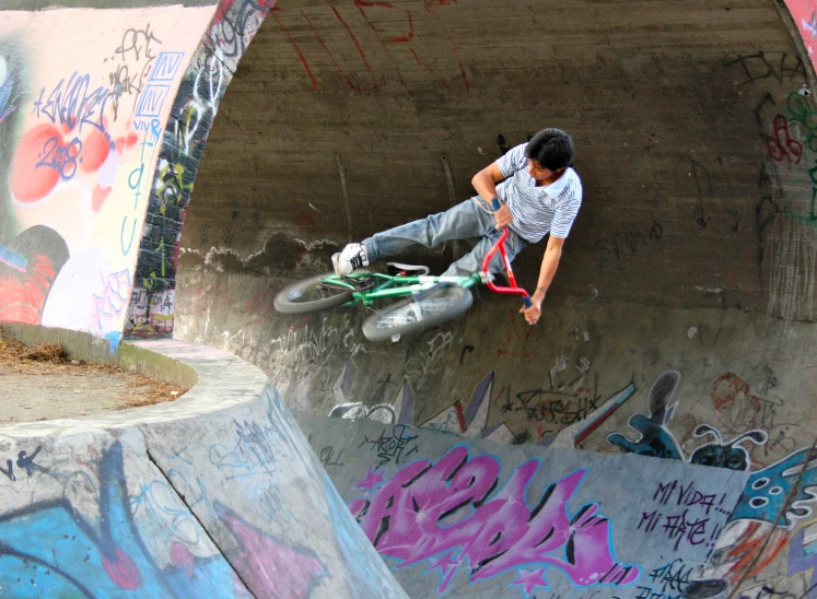 a boy doing tricks on a skateboard at the top of a half pipe