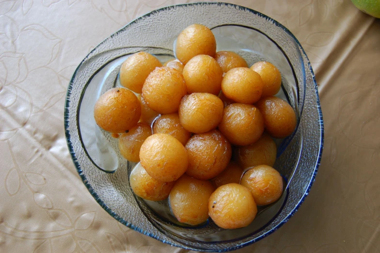 the oranges are sitting in a clear glass bowl