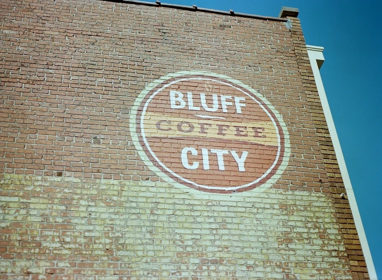 a brick wall with graffiti on it that reads bluff city