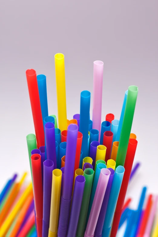 a glass of assorted colored drinking straws