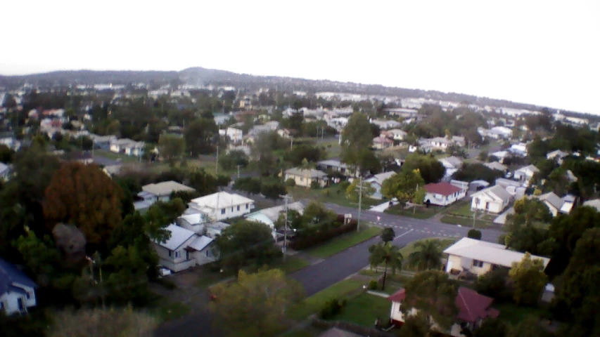 a view of an intersection from above of trees and houses