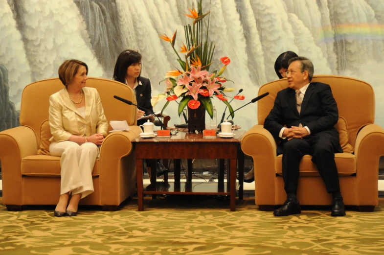 three people are sitting in chairs near each other