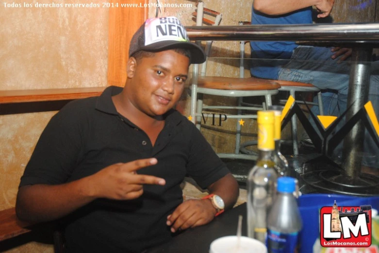 a man sitting at a bar with bottles on the counter