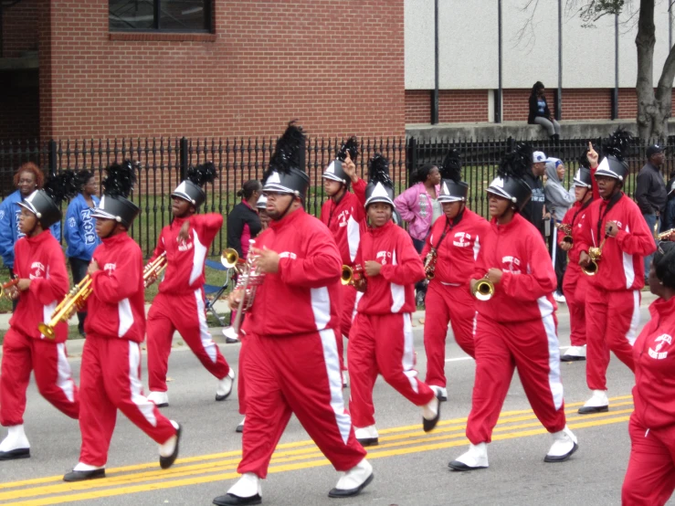 a marching band in red performing in a parade