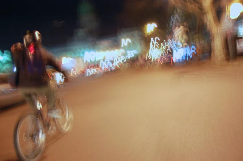 people in street on bicycles, at night
