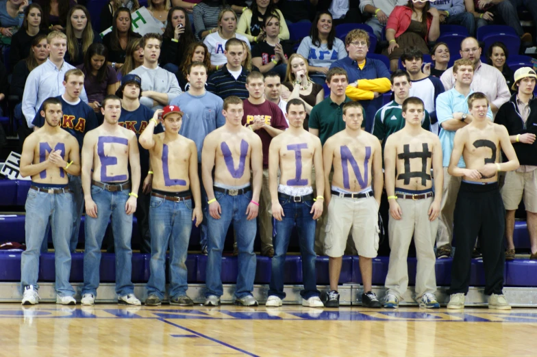 a group of boys holding up signs on the side of a court