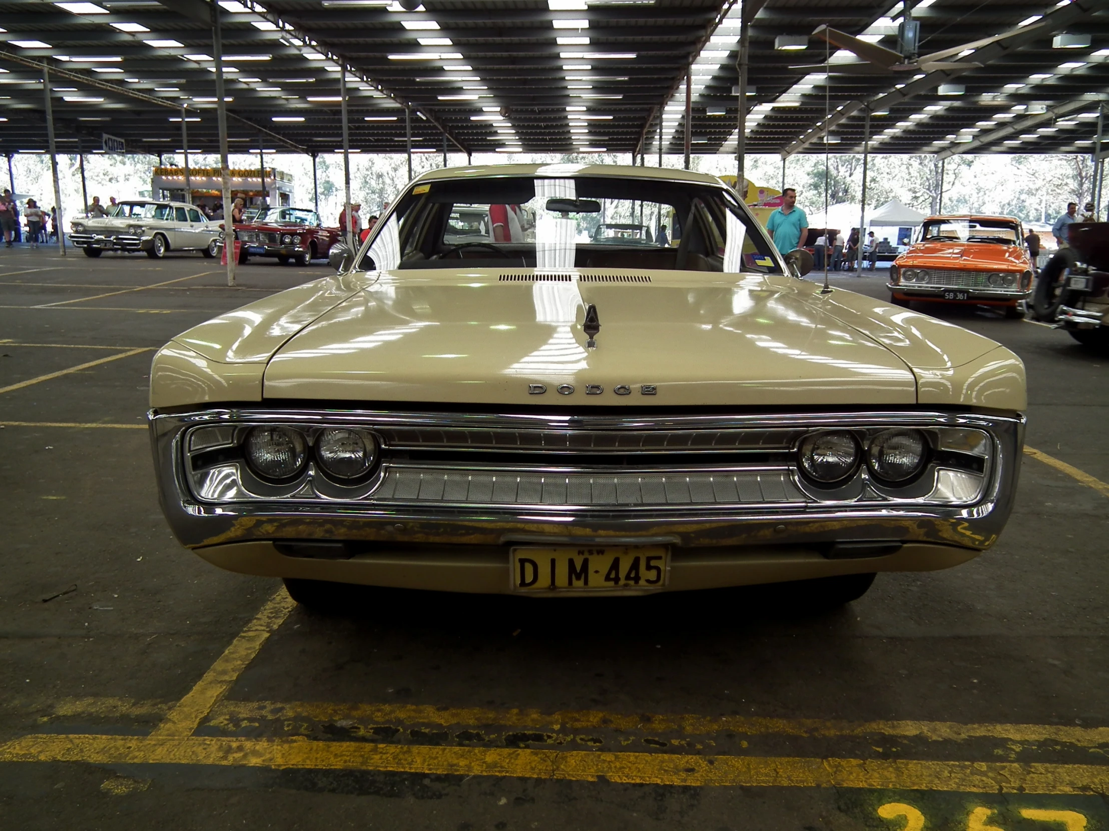 an old yellow car sits in a garage