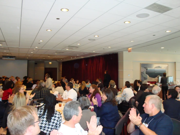 a large group of people sitting in front of microphones at a convention