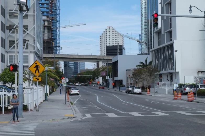 a view down a city street with cars parked on the sidewalk