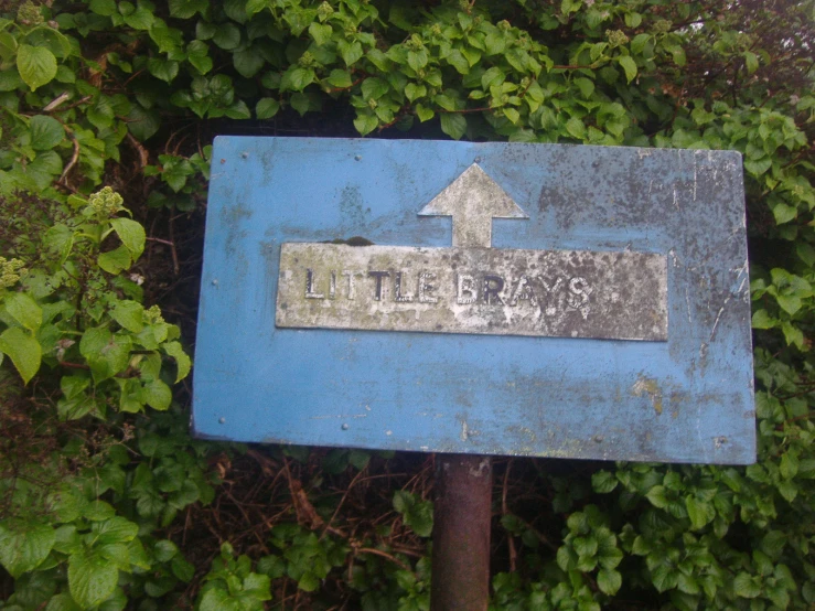 an old blue sign with the word littler and an arrow pointing to it