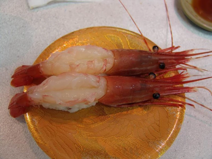 two shrimp pieces on a yellow plate on a table